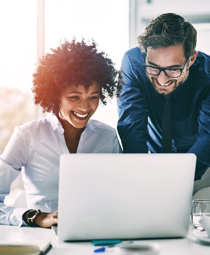Business people, laptop and meeting in planning, teamwork or coaching for project on bokeh background at office. Group of happy employees working on computer for schedule plan, ideas or team strategy.